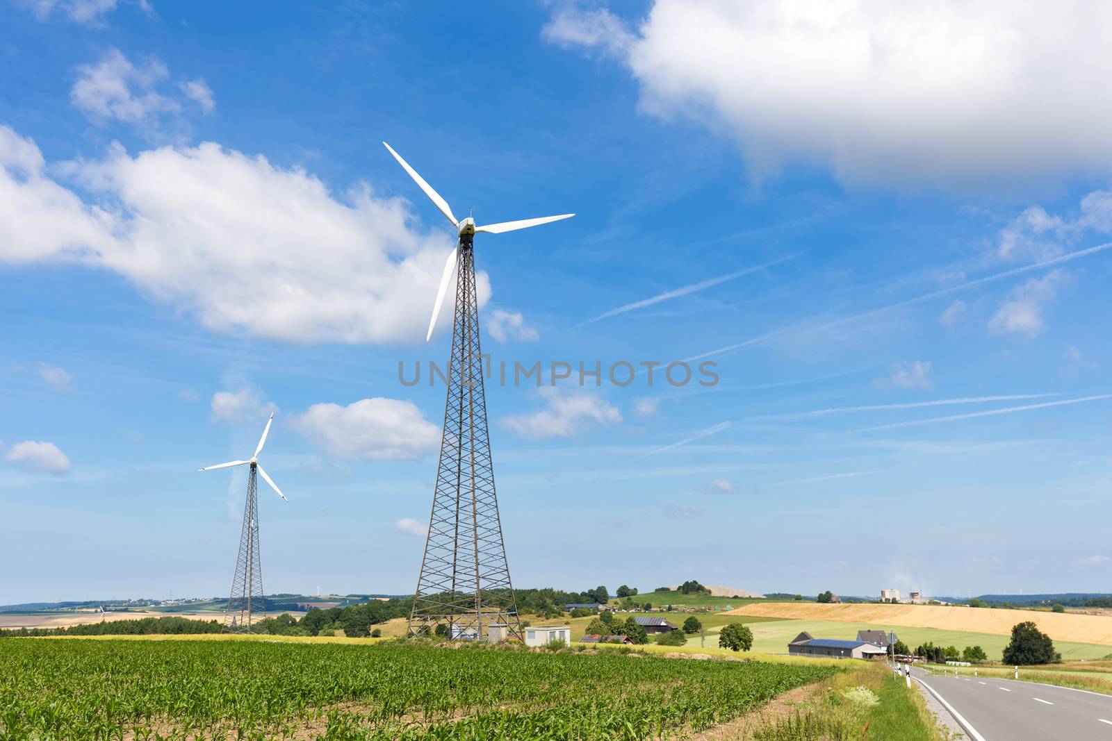 Two windmills in countryside with blue sky and white clouds in Germany