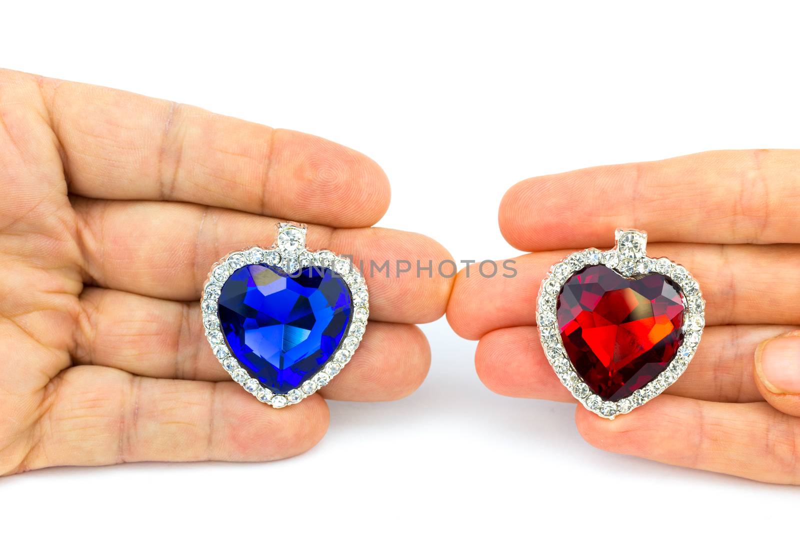 Two jewelry hearts on hand of man and woman by BenSchonewille