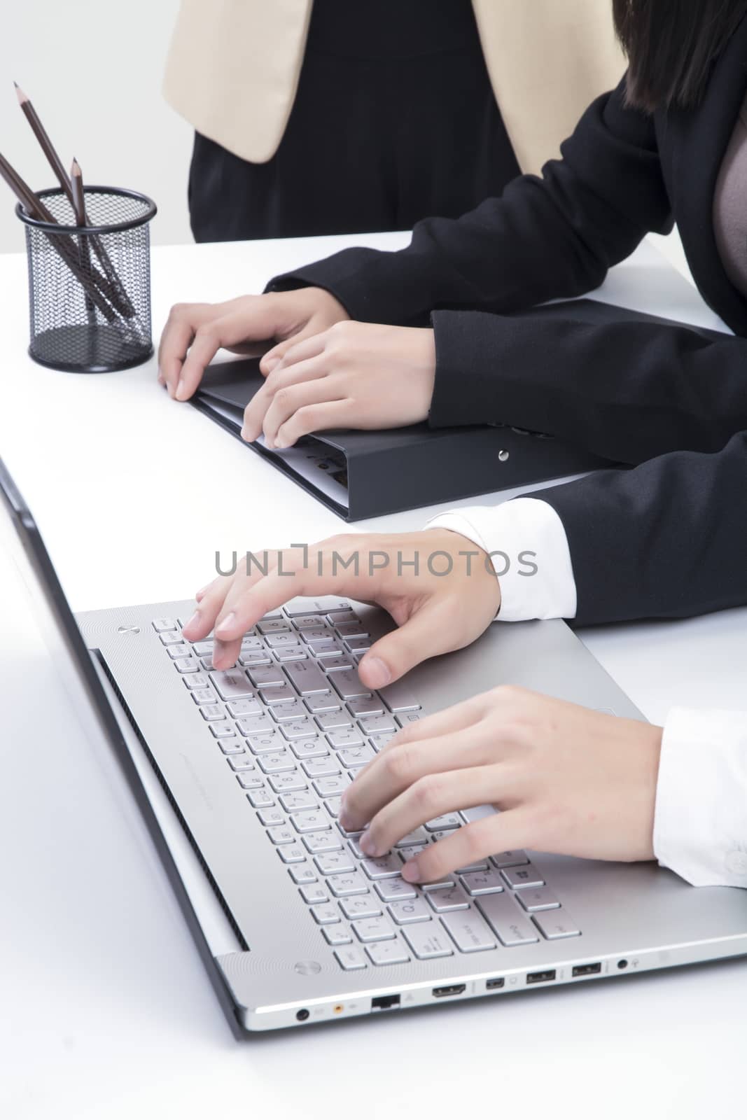 Three asian business in office, discussing document on computer, hand typing profile