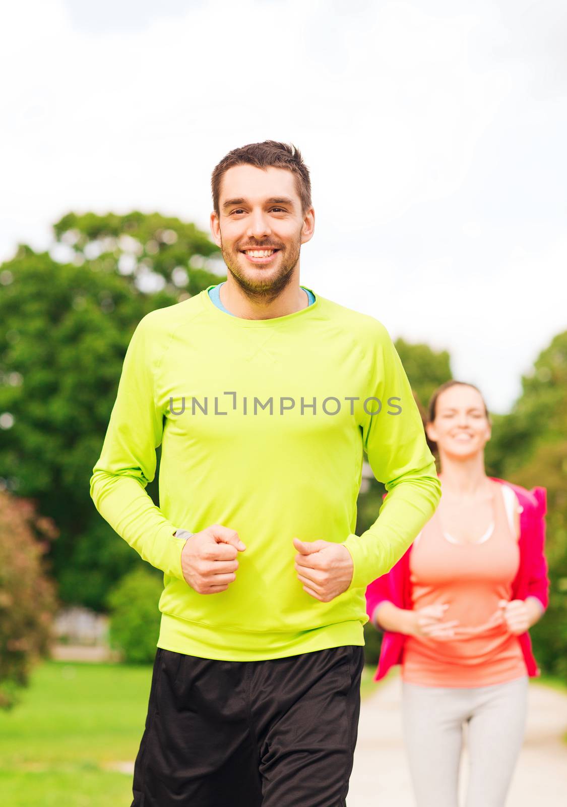 smiling couple running outdoors by dolgachov