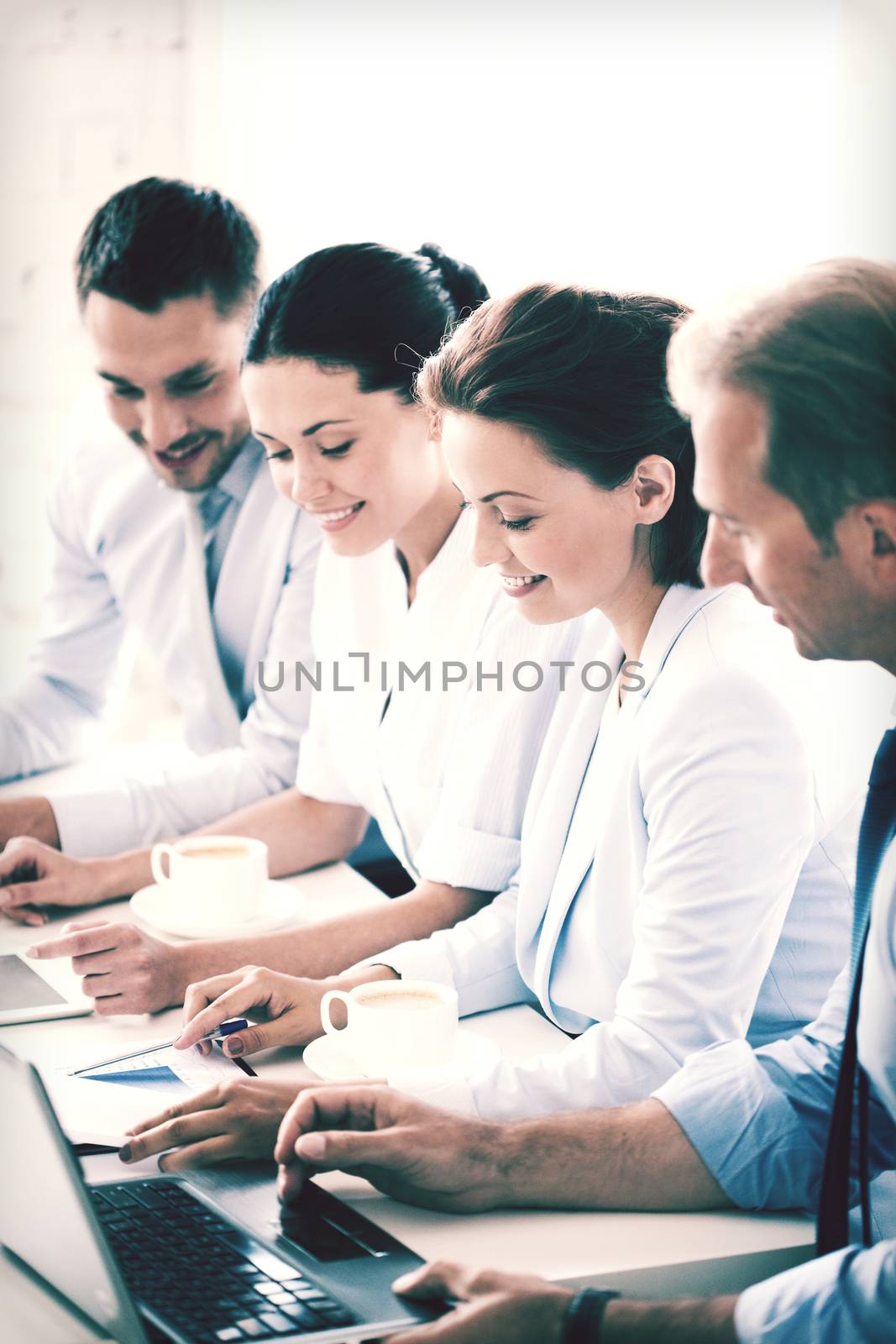 group of people working with laptops in office by dolgachov