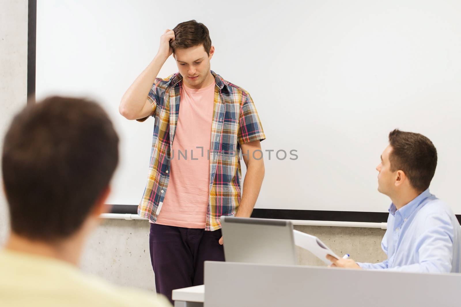 education, high school, technology and people concept - students and teacher with notepad, laptop computer in classroom