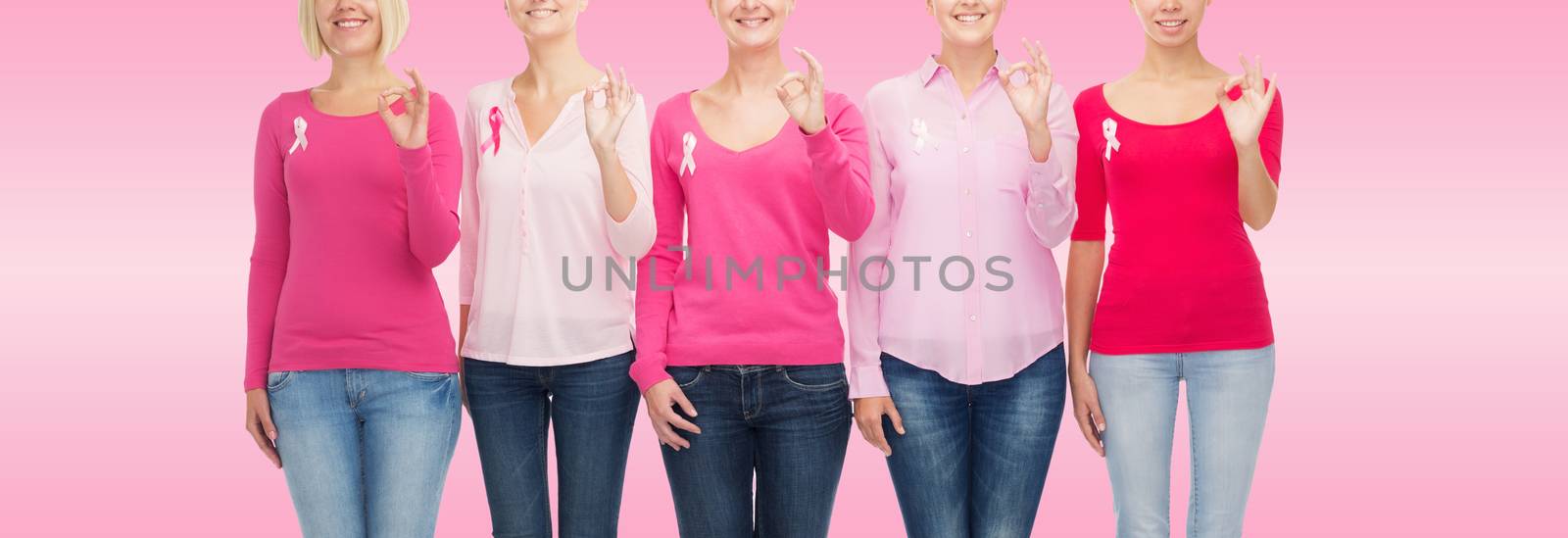 healthcare, people, gesture and medicine concept - close up of smiling women in blank shirts with breast cancer awareness ribbons showing ok sign over pink background