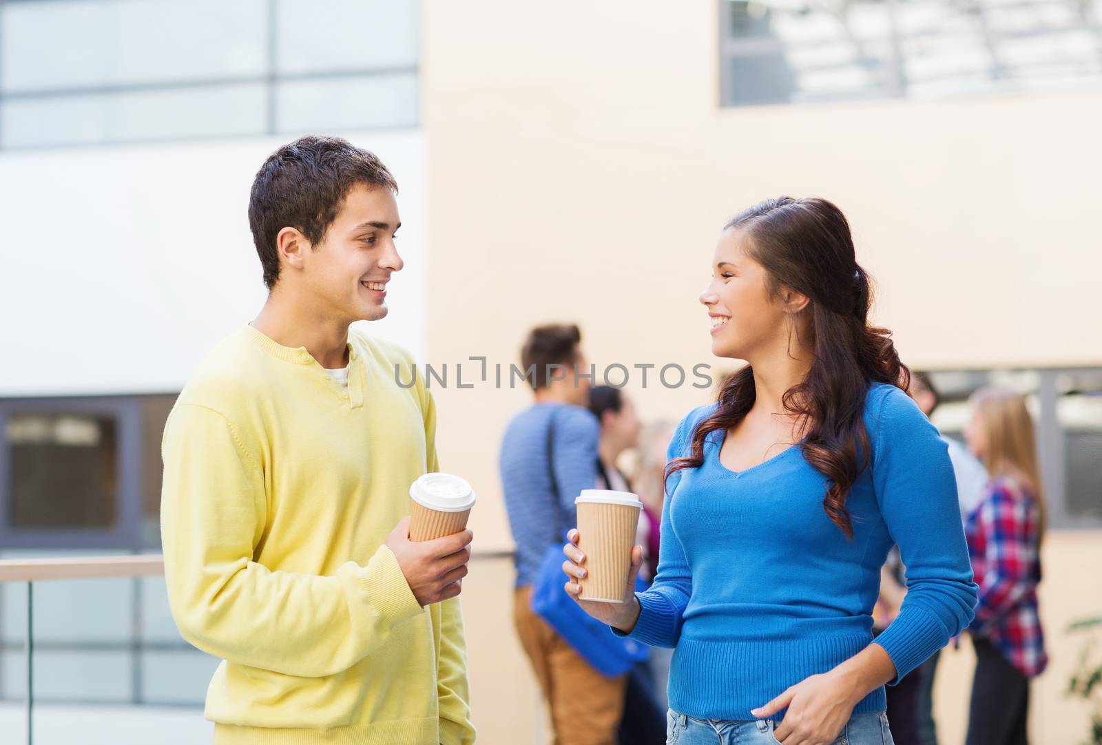 friendship, people, drinks and education concept - group of smiling students with paper coffee cups outdoors