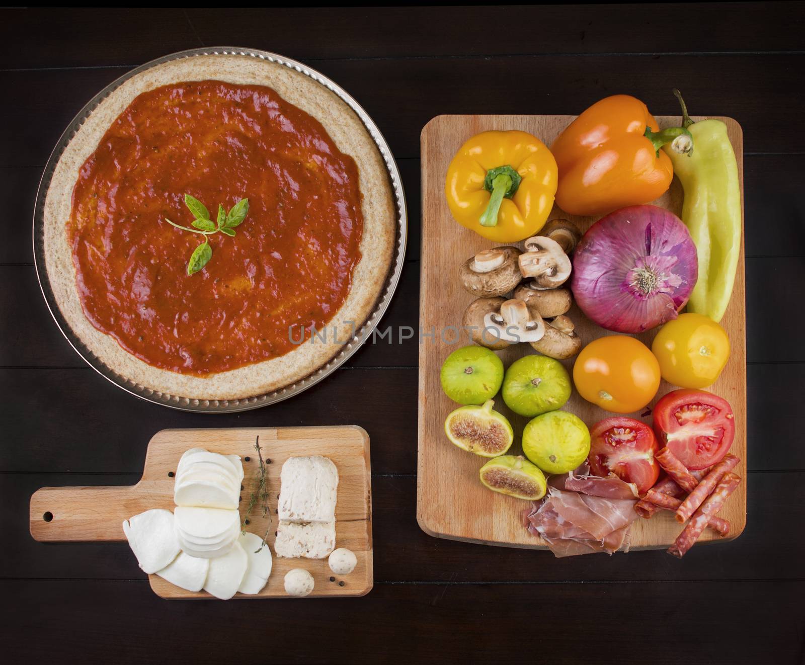 Rustic home made pizza on wooden table with fresh ingredients and cheese