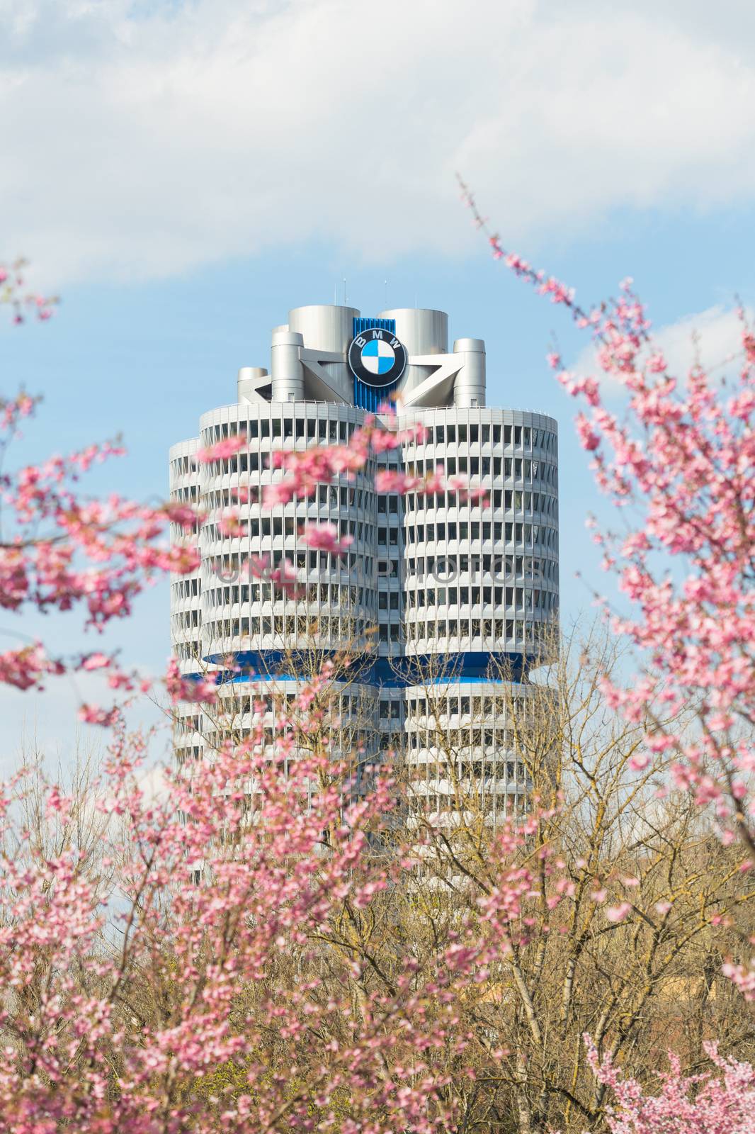 Munich, Germany - April 12, 2015: BMW headquarters high-rise tower office building in spring blossoming Olympiapark.