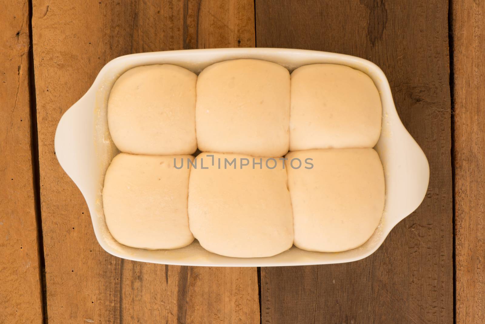 baking dish with yeast dough in the form of an bun