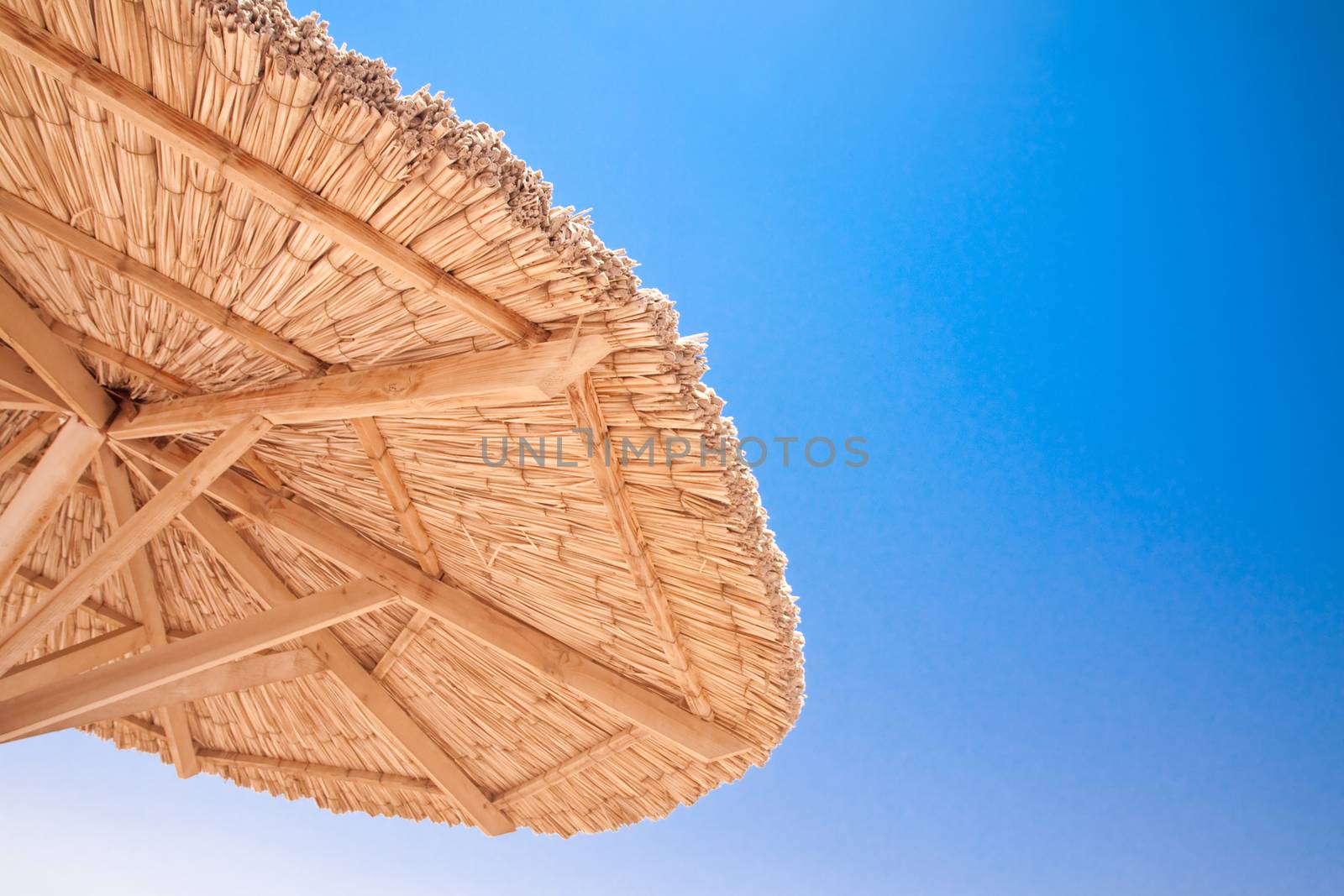 The sun umbrella on a background of blue sky