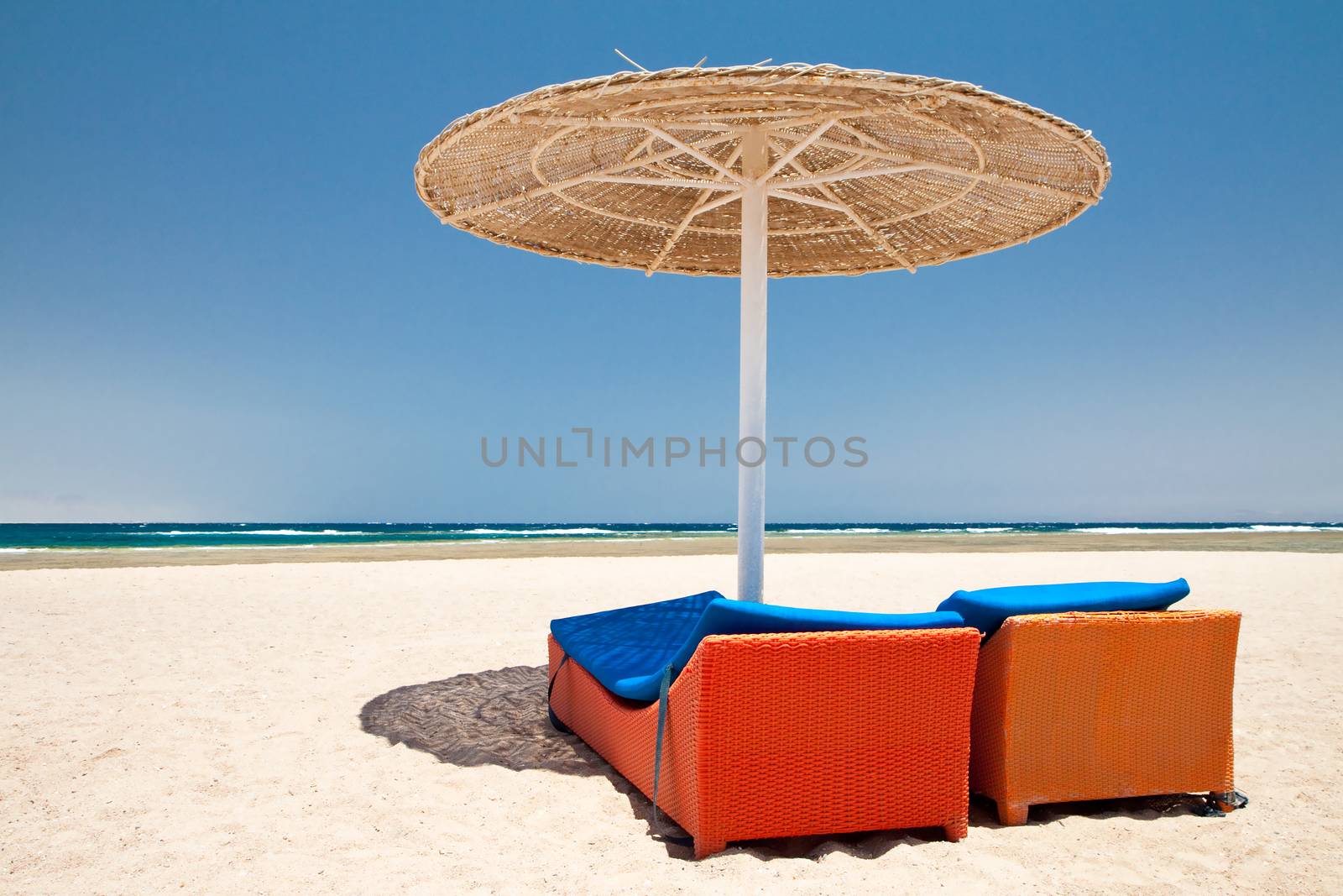 Parasol and sun loungers on the beach