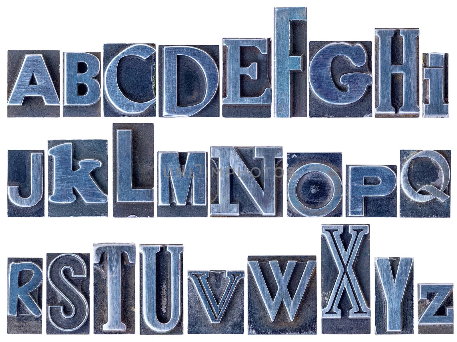 English alphabet - a collage of 26 isolated letters in letterpress metal type printing blocks, a variety of mixed fonts stained by blue ink
