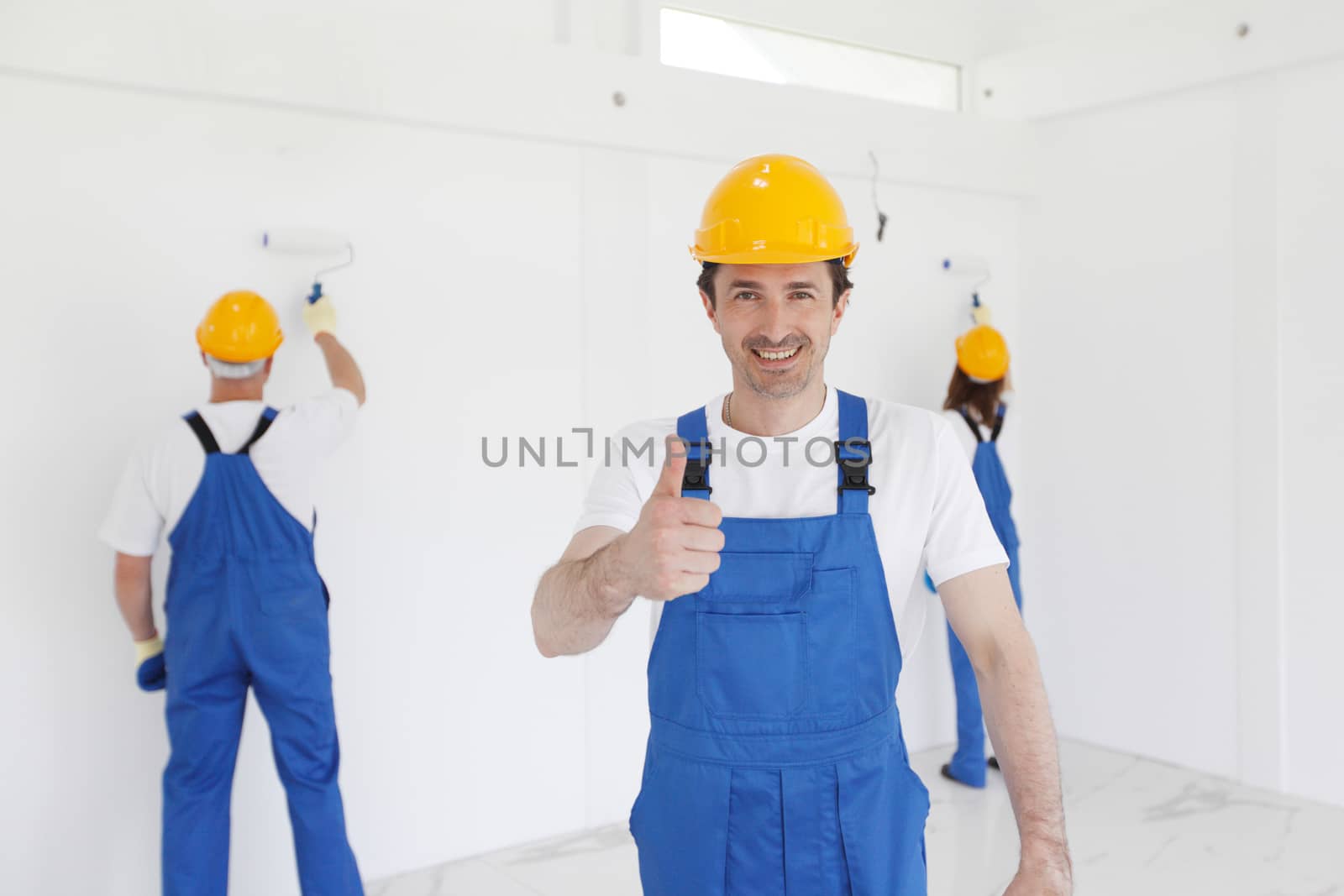 workman gives thumbs up in front of two painters