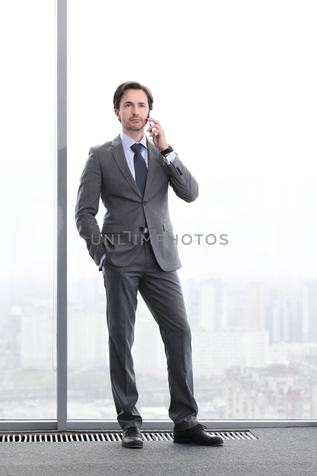Businessman talking by phone by ALotOfPeople