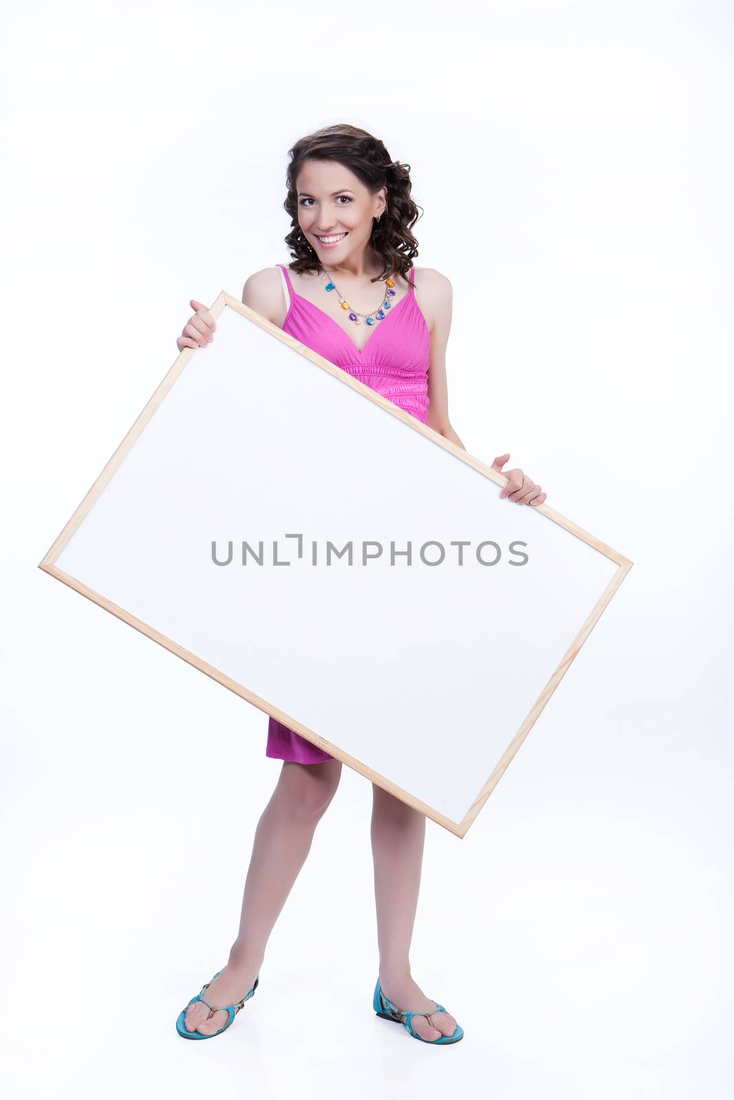 Young smiling woman holding a white board on isolated studio background