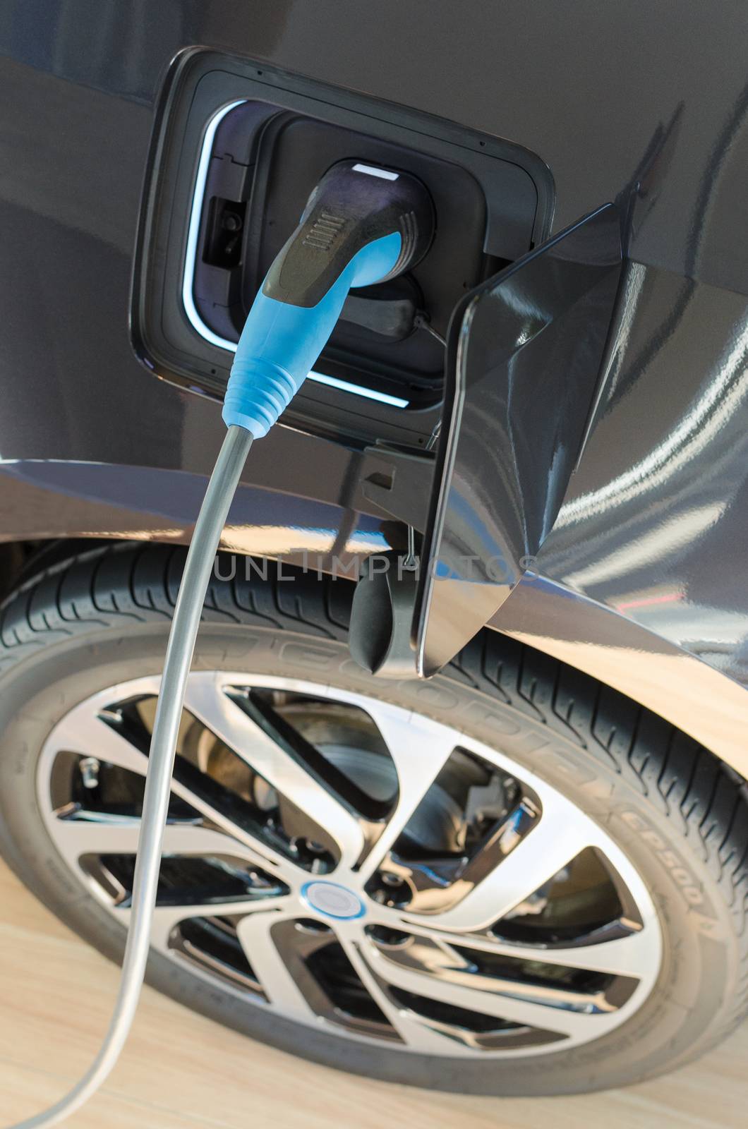 Modern electric car plugged in to power supply charging station by servickuz