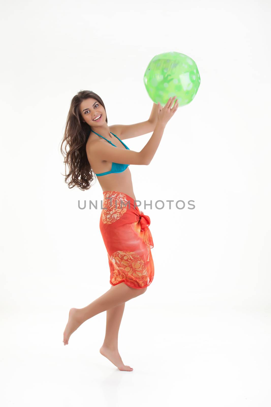 Young beautiful woman plays with a ball on isolated studio bakground