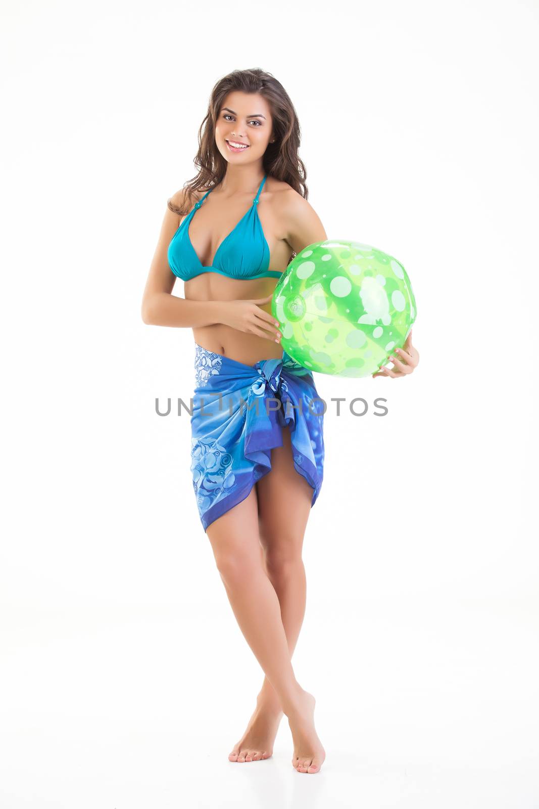 Young beautiful woman plays with a ball on isolated studio bakground