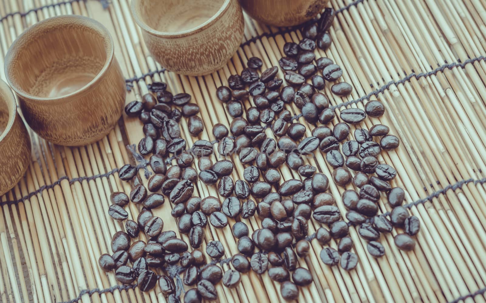 Coffee beans and coffee cup set on bamboo wooden background.Photo in retro color image style, Soft focus.