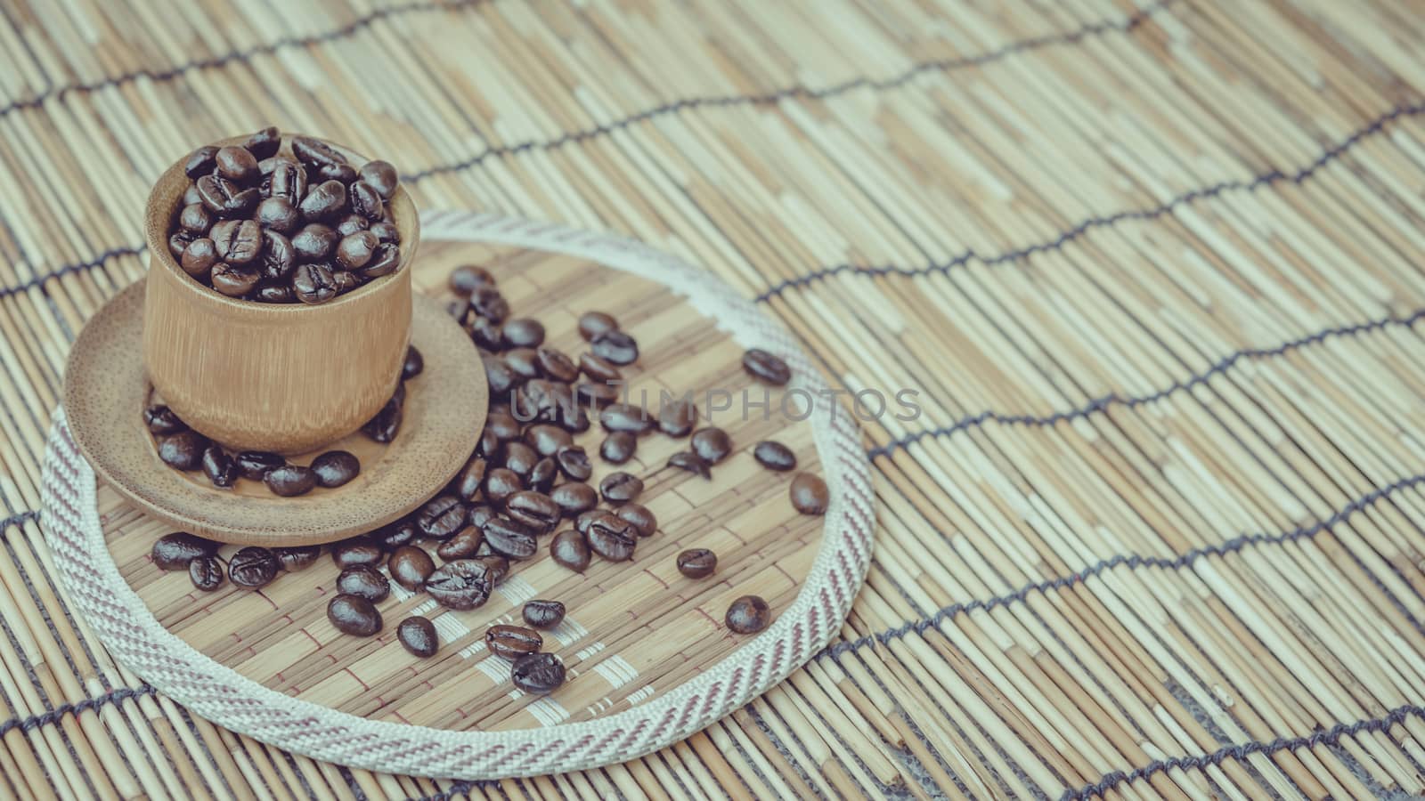 Coffee beans and coffee cup set on bamboo wooden background.Photo in retro color image style, Soft focus.