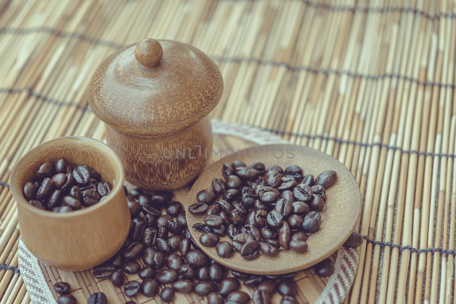 Coffee beans and coffee cup set on bamboo wooden background.Photo in retro color image style, Soft focus.