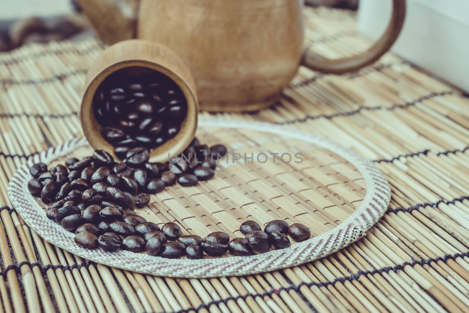 Coffee beans and coffee cup set on bamboo wooden background.Photo in retro color image style, Soft focus.