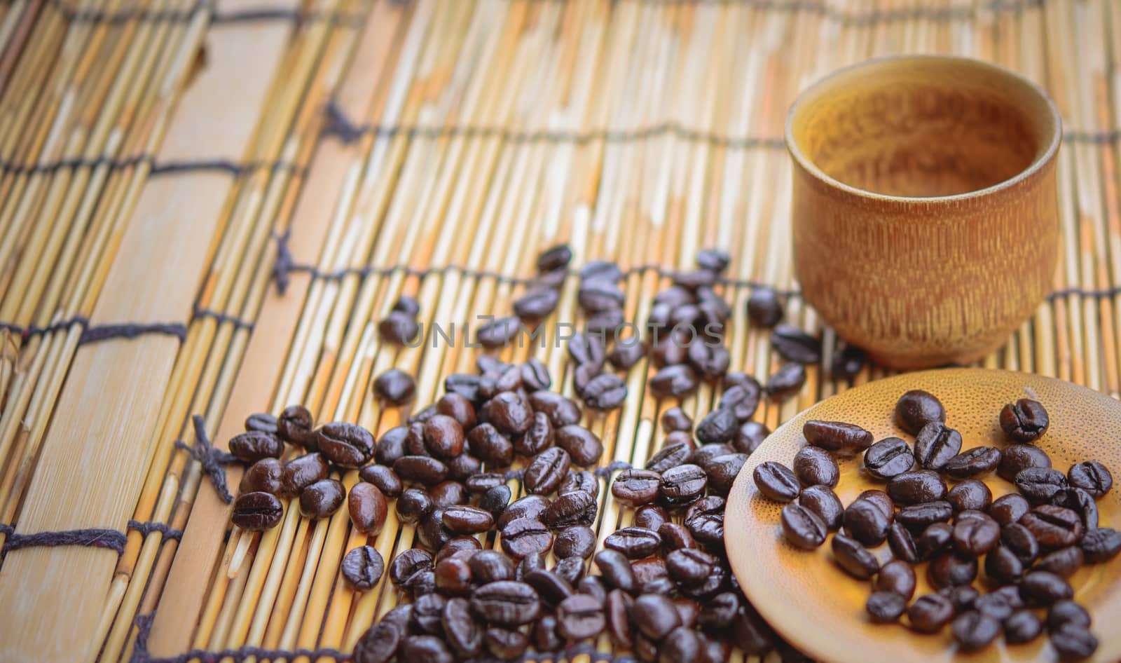 Photo in vintage color image style.Coffee beans and coffee cup set on bamboo wooden background.Soft focus.