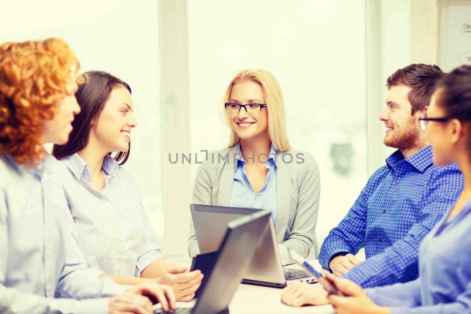 smiling team with laptop and table pc computers by dolgachov