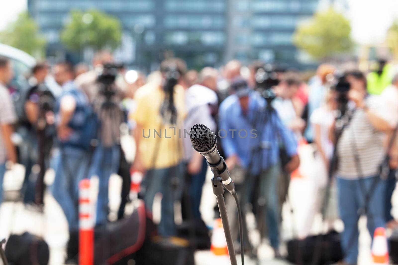 News conference. Microphone in focus against blurred background.
