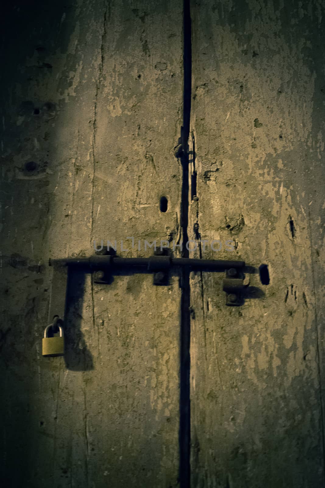 old wooden door with new padlock consumed