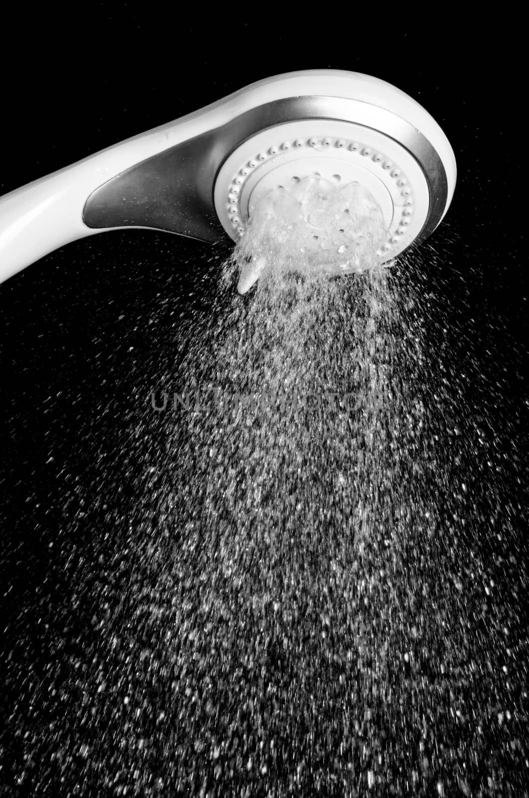 Modern shower head with running water isolated on black background