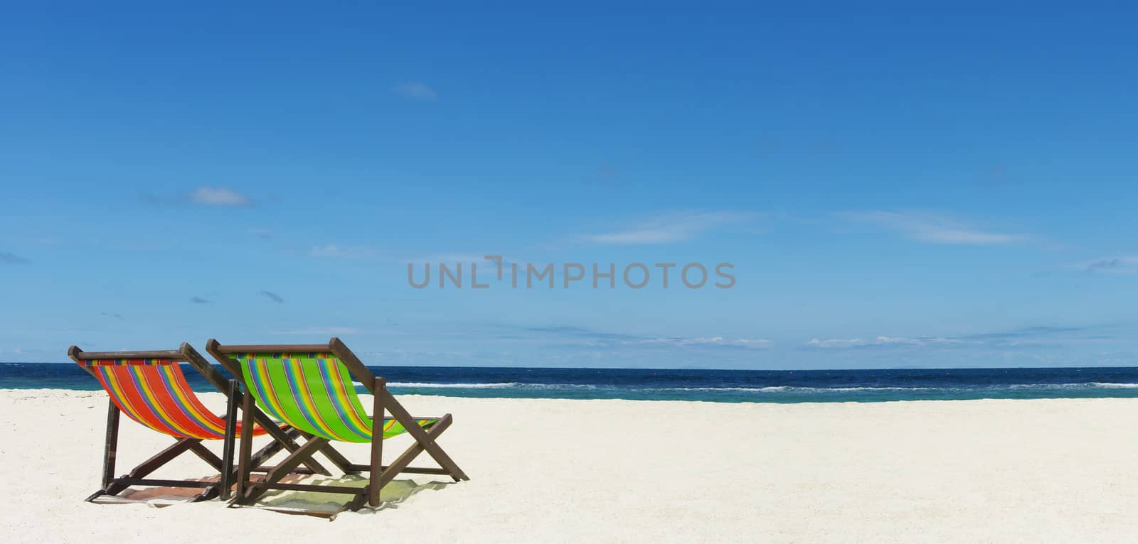 Beach chair on sand beside nice sea, Summer time concept by pixbox77