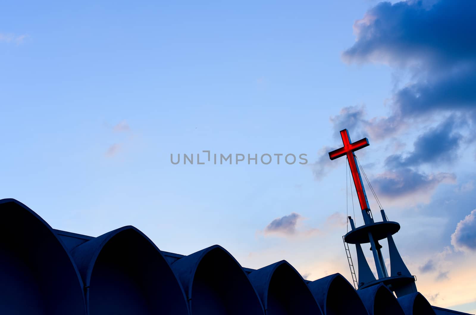 Cross at top of chruch with sunset sky background