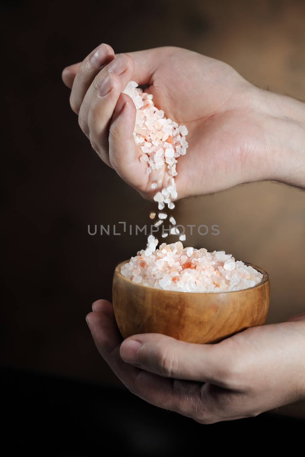 Man pouring himalayan salt crystals from his hand.