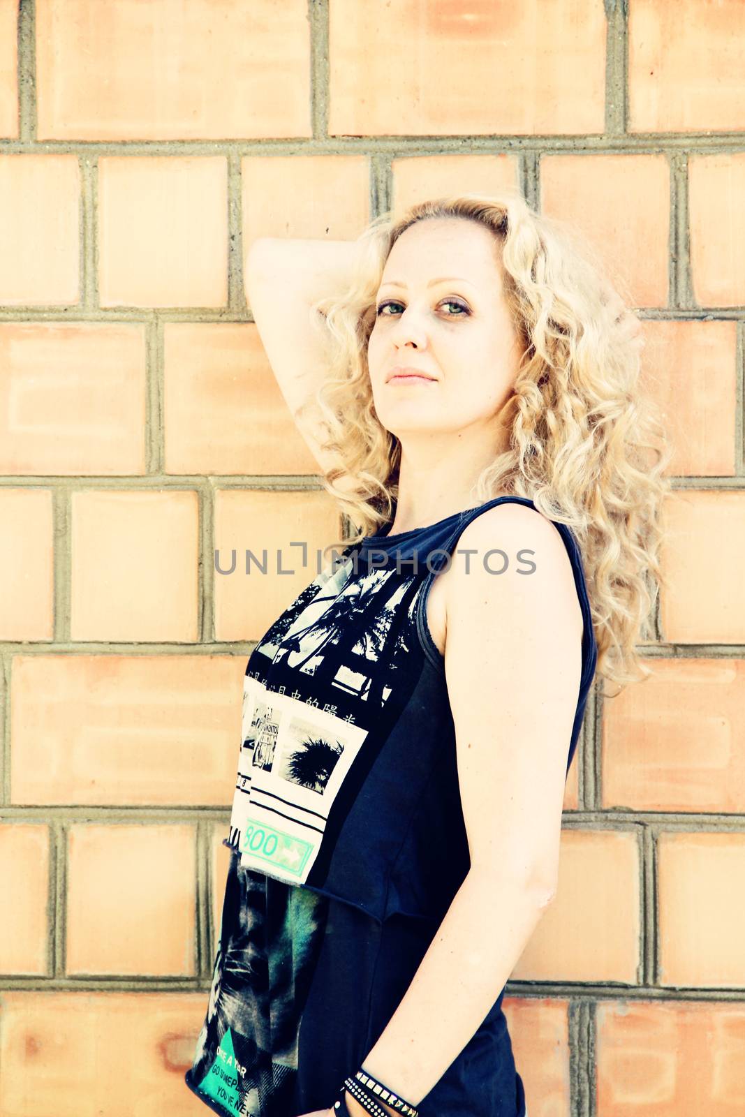 woman or girl near a brick wall