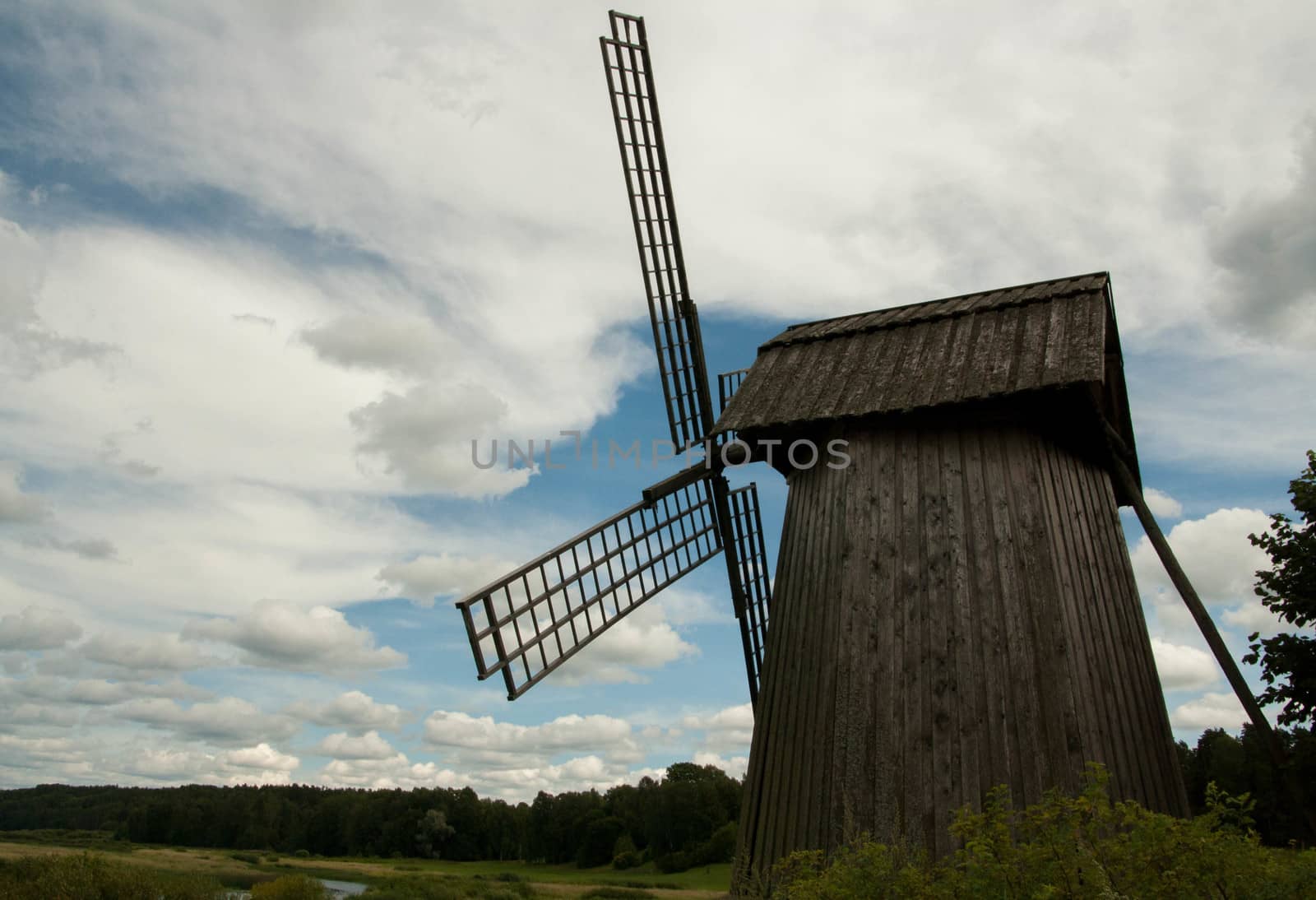 old windmill in a field near the river  by alexx60