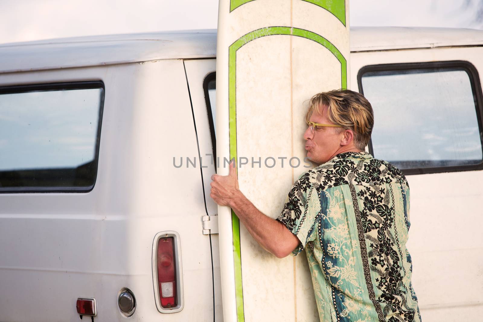 One middle aged man lifting heavy surfboard