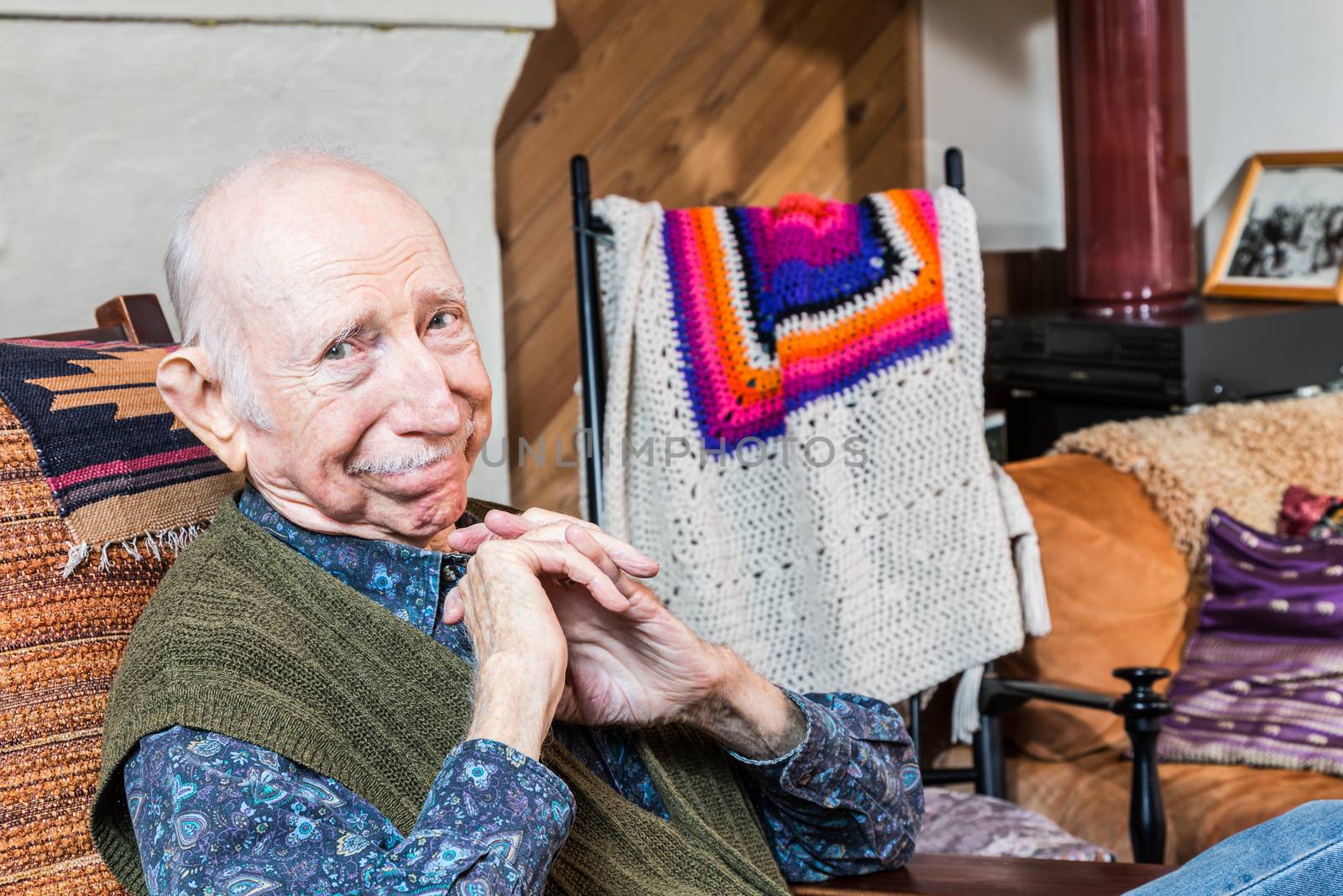 Smiling elderly man sitting on a chair indoors