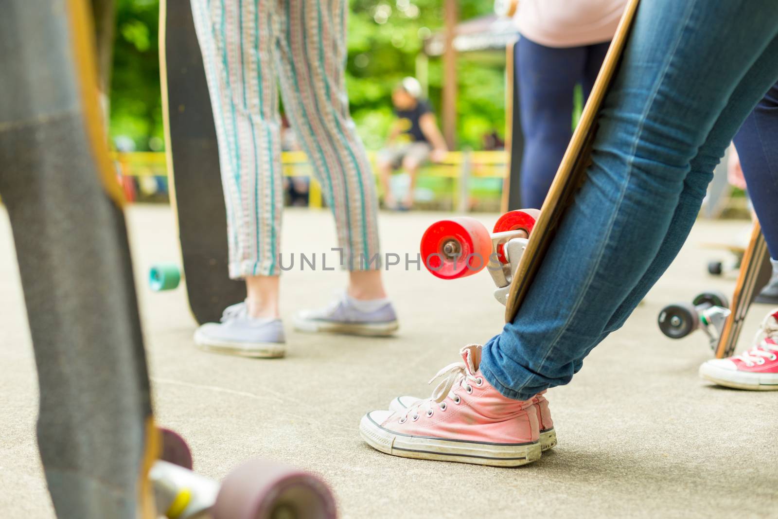 Teenagers practicing long board riding in skateboarding park. Active urban life. Urban subculture.