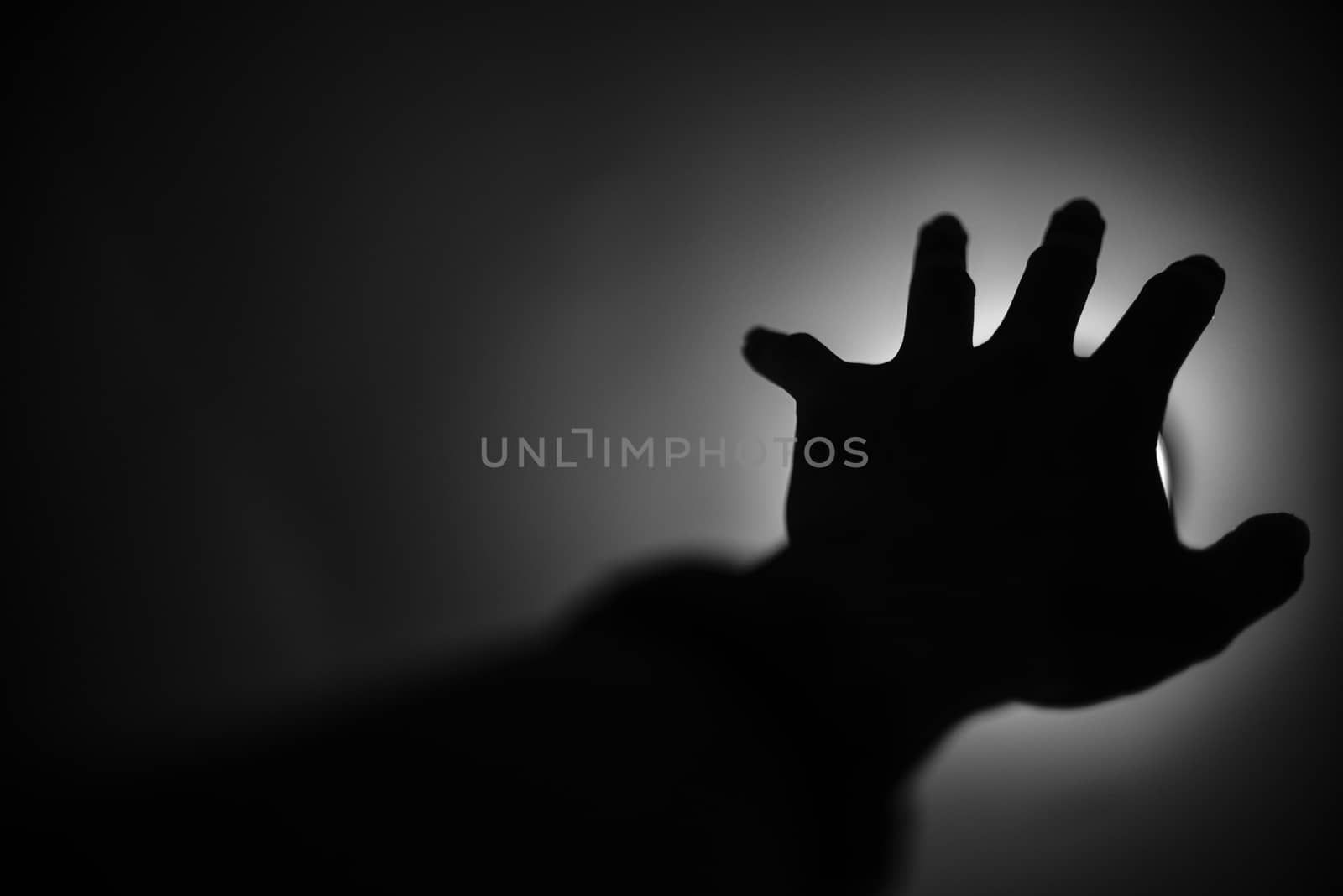 Silhouette of hand reaching to light, Help me concept by pixbox77