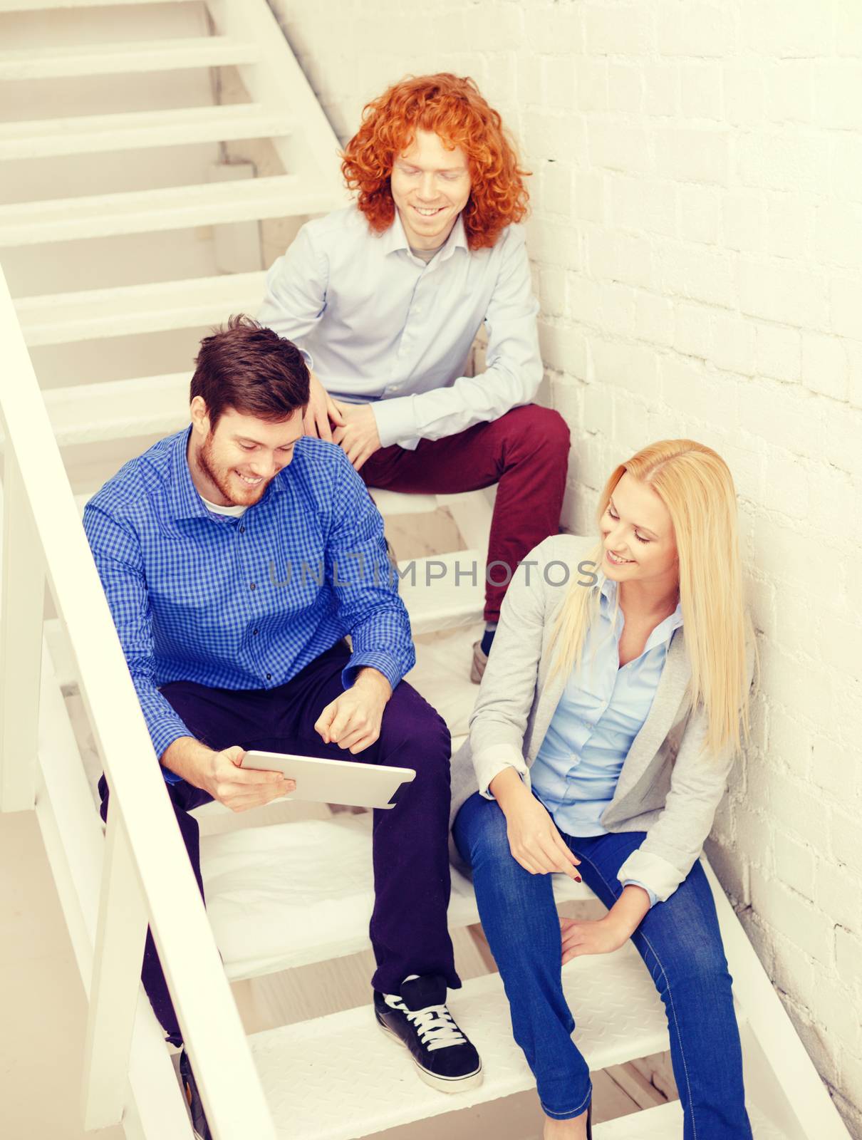 team with tablet pc computer sitting on staircase by dolgachov