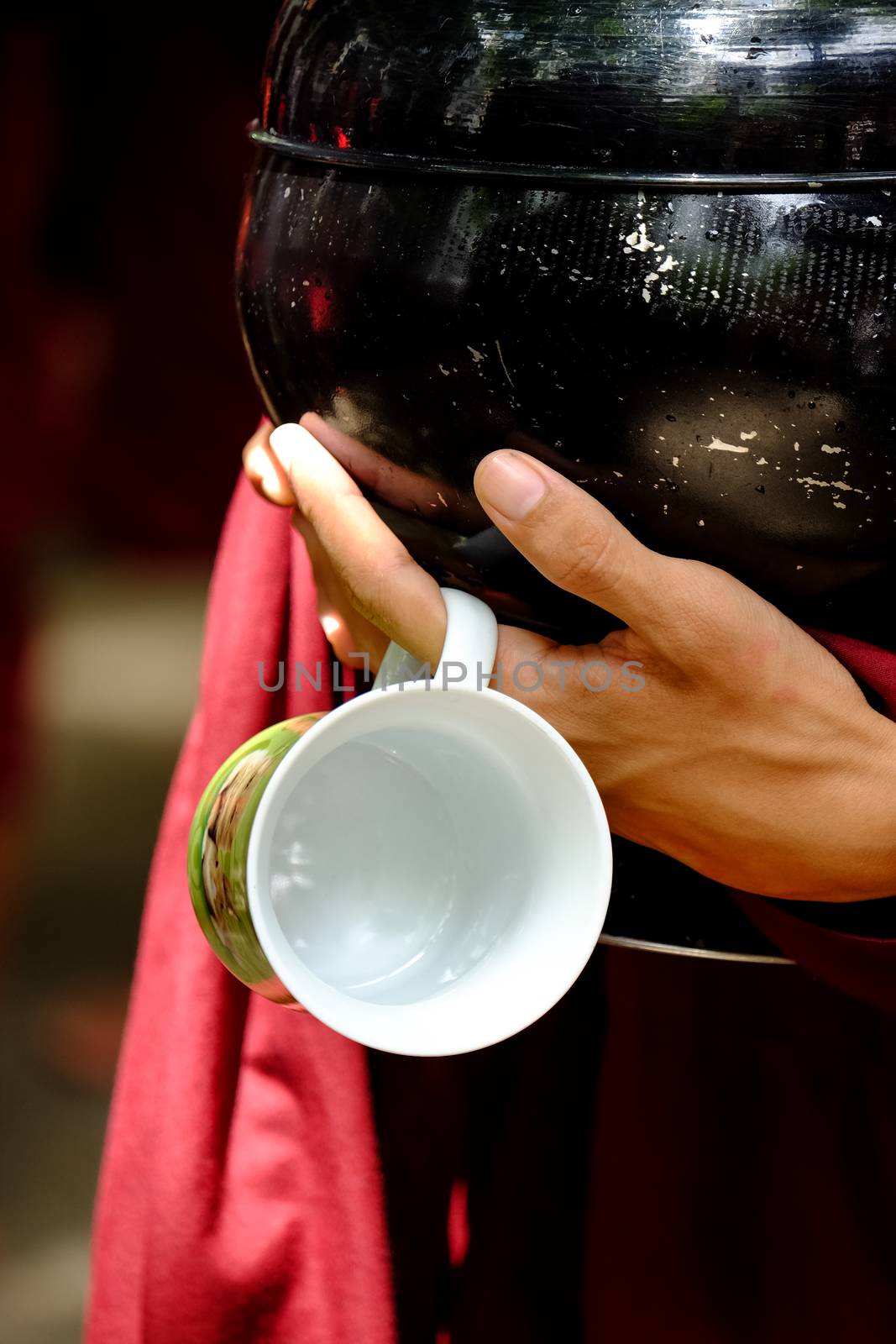 Close up of buddhist monk hands holding a vintage bowl and cup