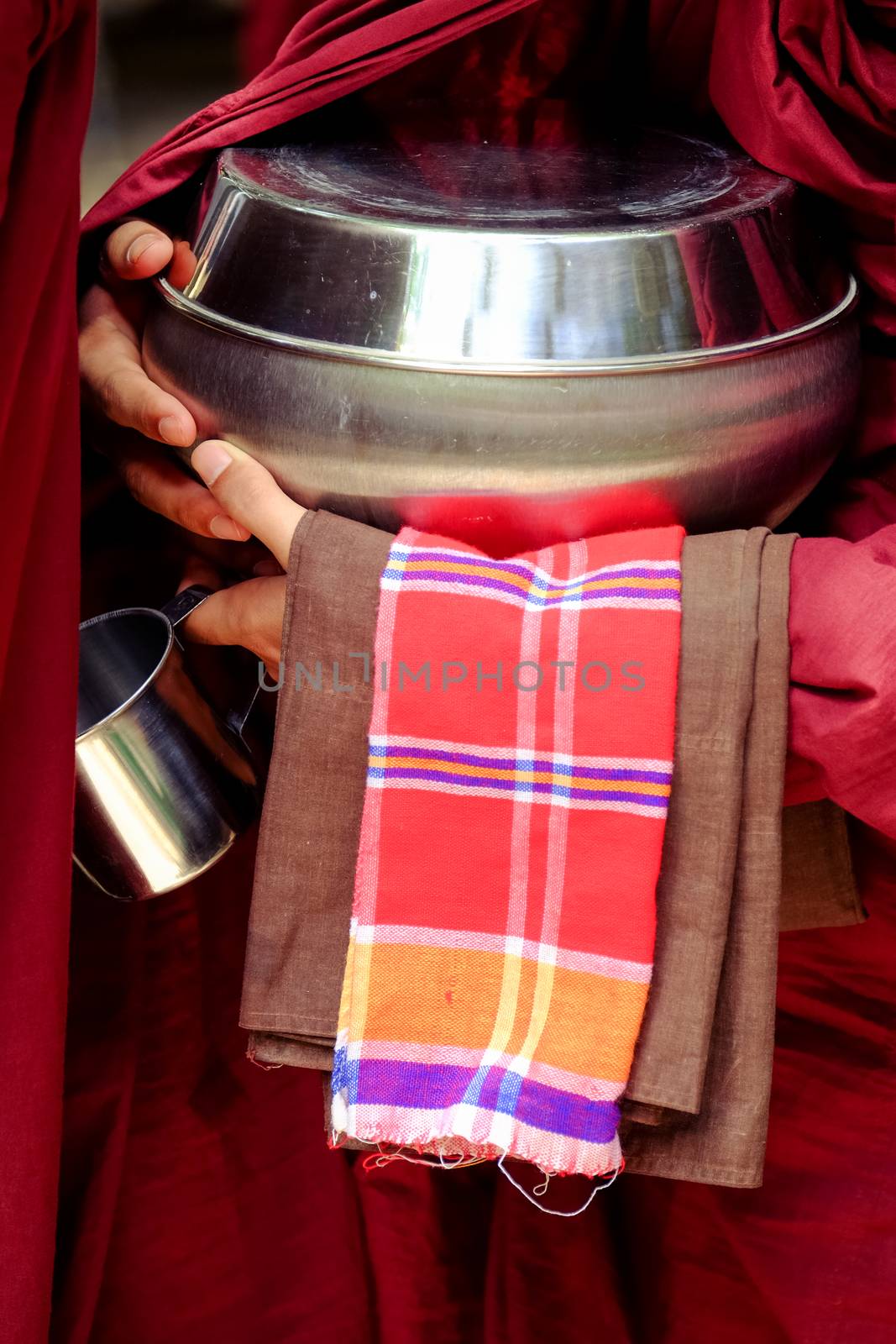 Close up of buddhist monk hands holding a bowl and cup by martinm303