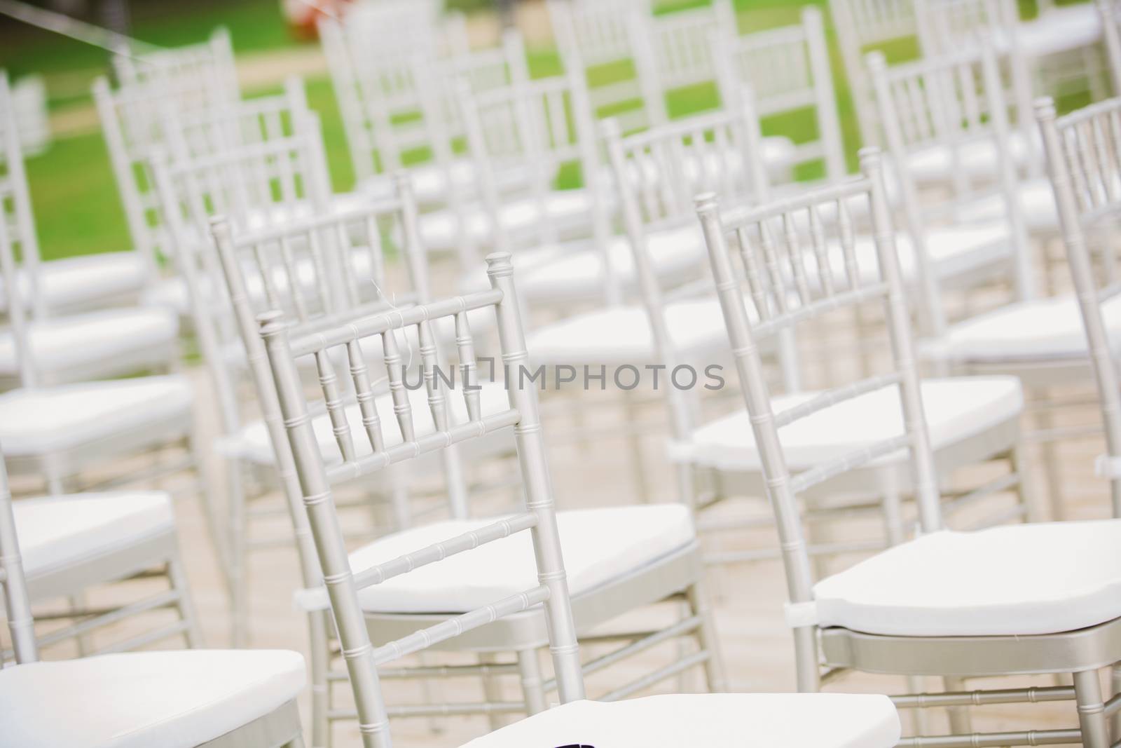Prior to a wedding ceremony, endless white chairs wait for their guests.