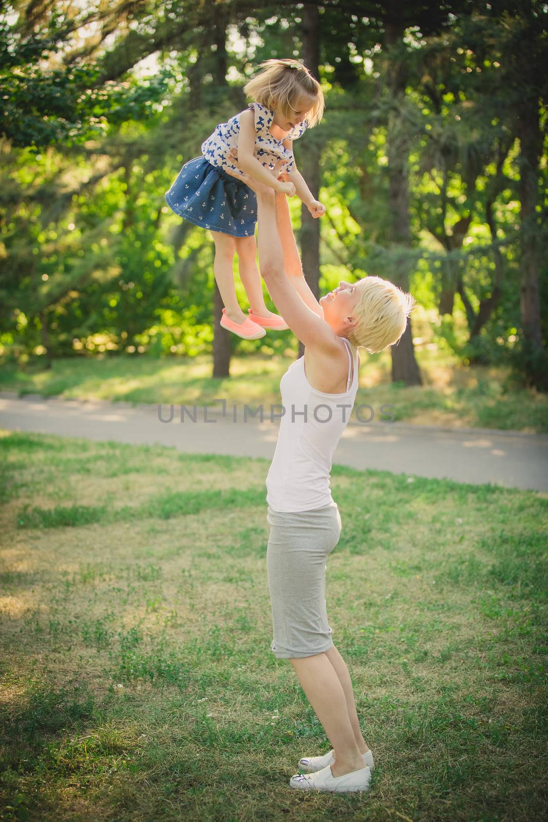 Mom playing with daughter in the park. Concept of a happy family