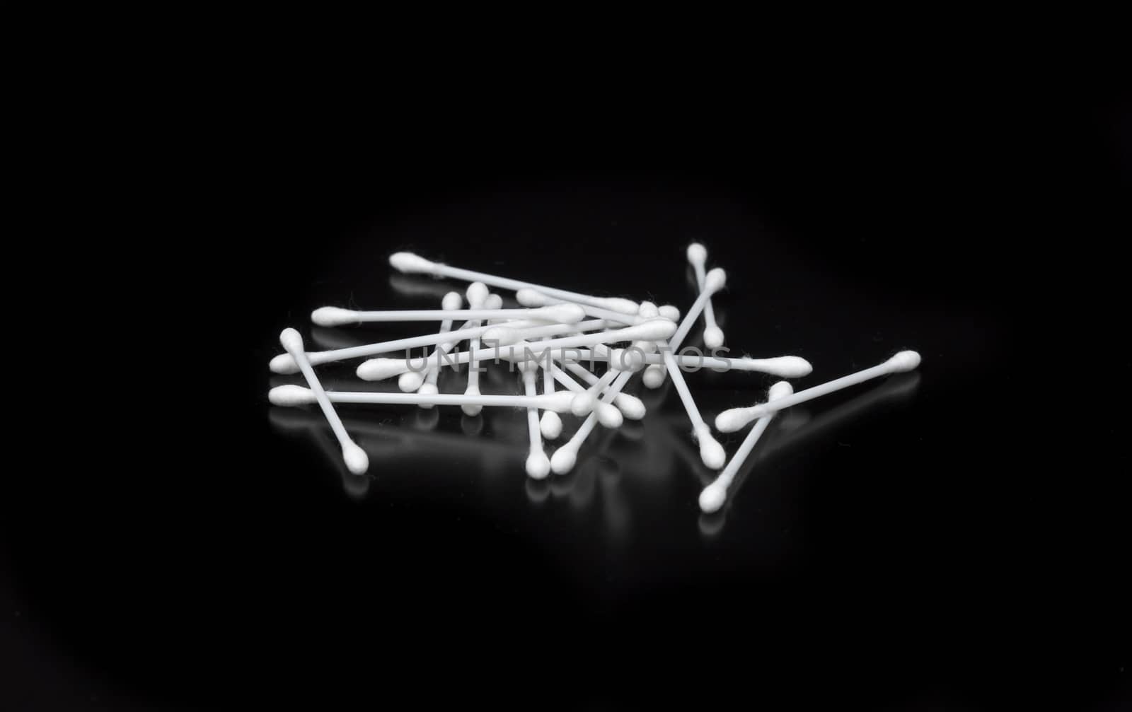 Cotton Swabs on Black Background lying on top pf each other.