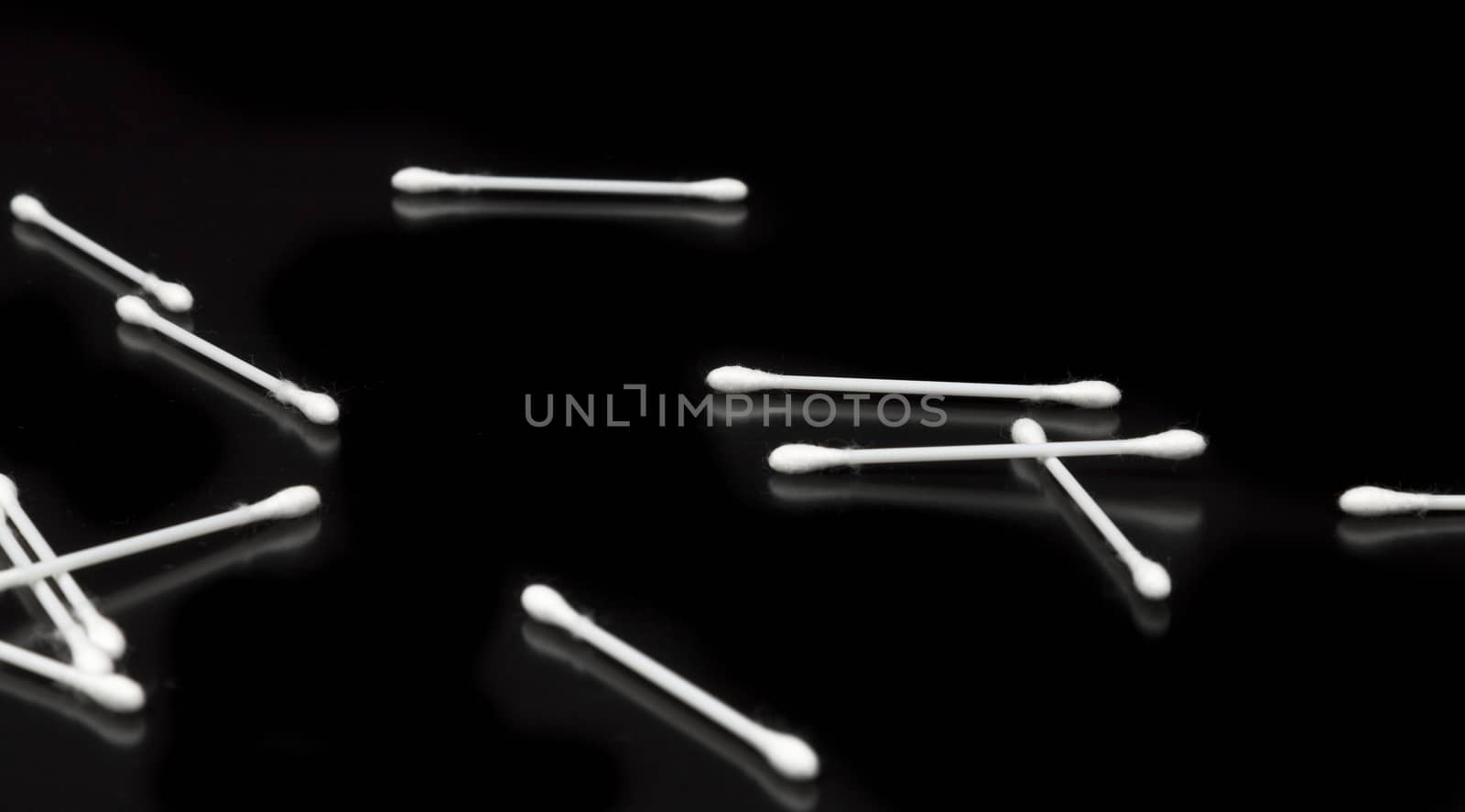 Cotton Swabs on Black Background Spread out.