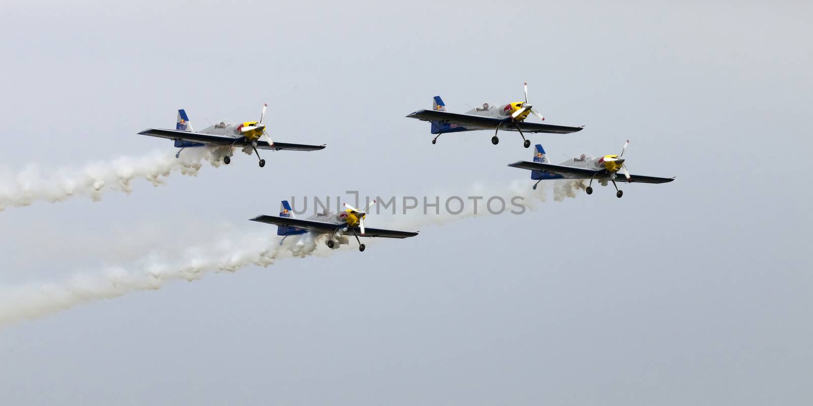 Plasy, Czech Republic - April 27, 2013: The Flying Bulls Aerobatics Team on the Airshow "The Day on Air". The team fly four modified Zlin Z-50 LX aircraft, painted in the colors of Red Bull energy drink for sponsorship reasons