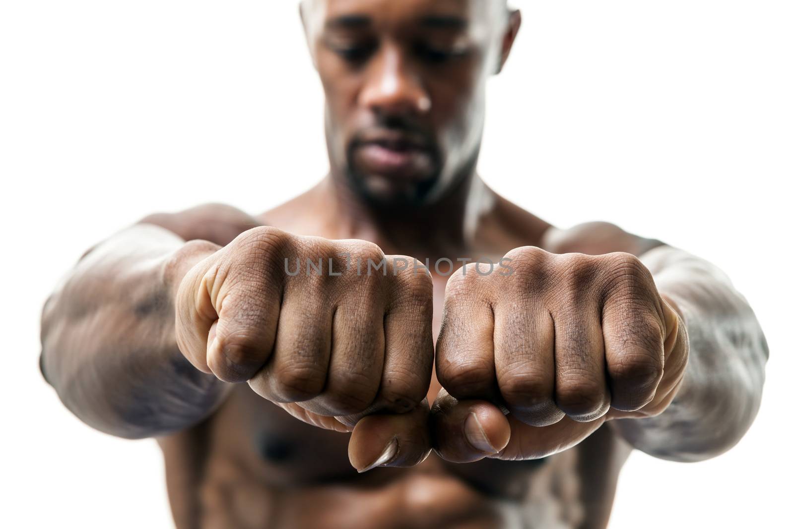 Muscular man of African descent isolated over a white background showing a closeup of his fists and knuckles.  Shallow depth of field.