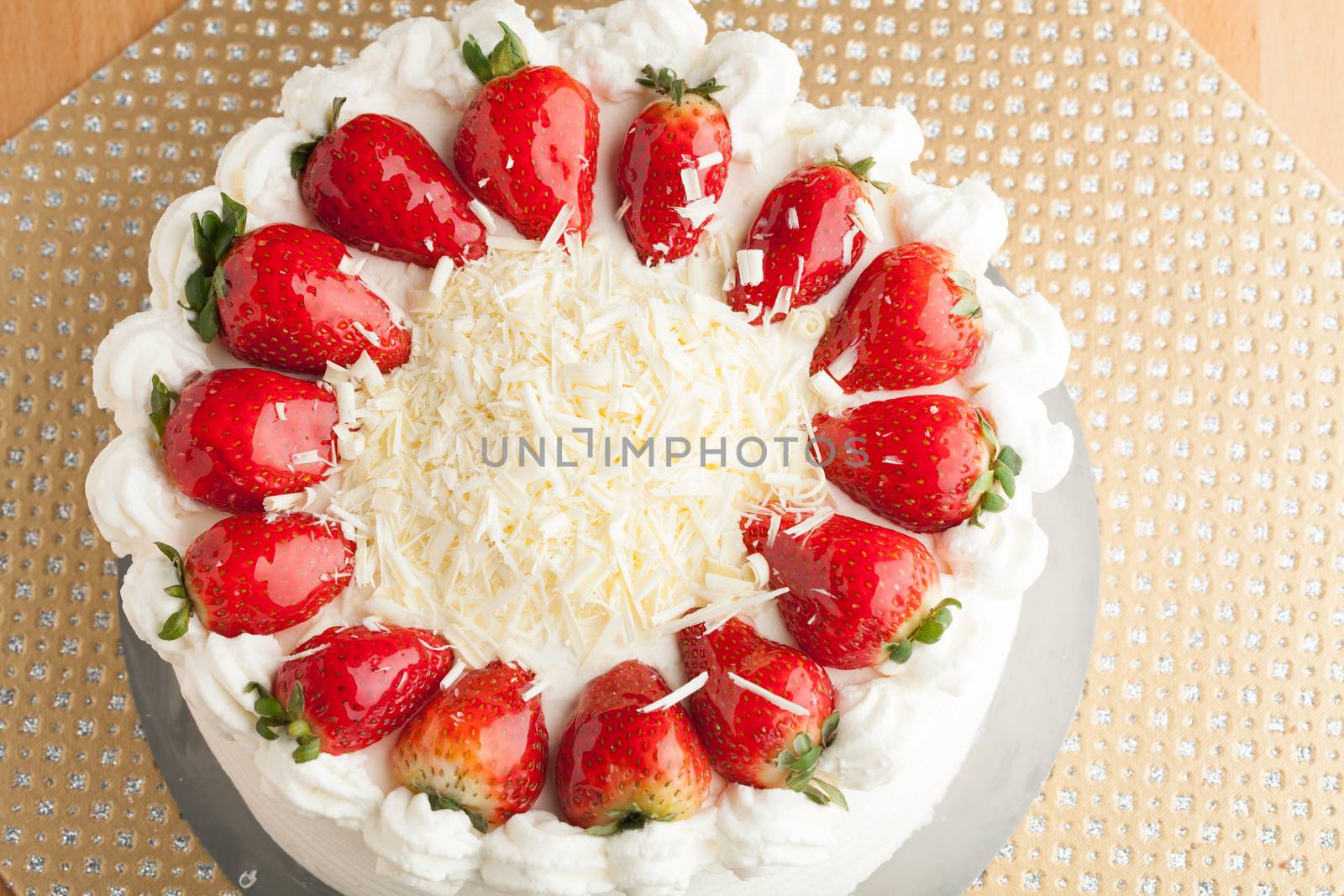 Top view of an entire strawberry shortcake with white chocolate shavings.  Shallow depth of field.