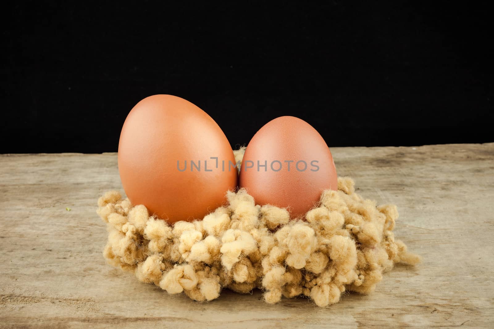 fresh brown eggs on wood background .