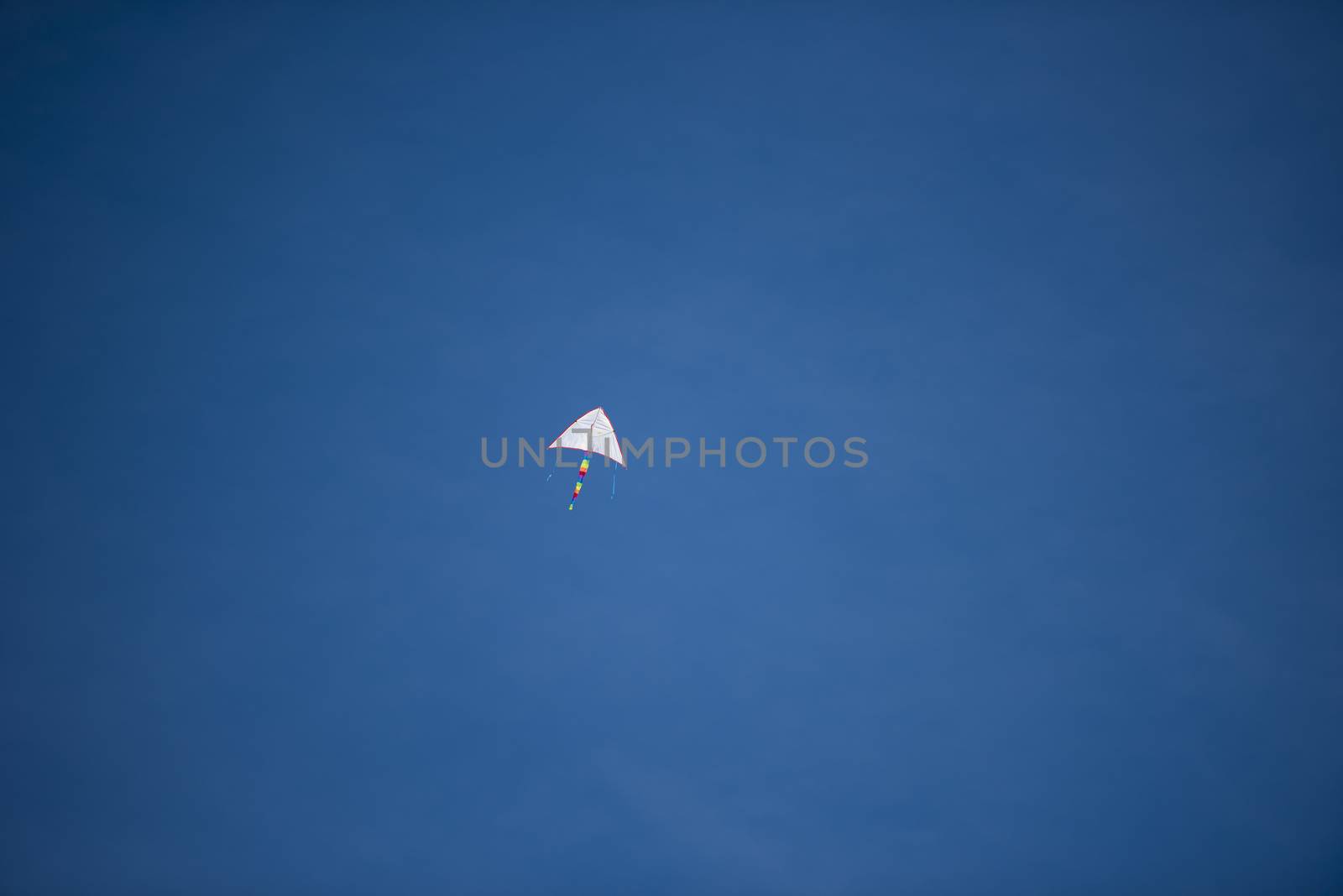 A bright colored kite soaring high in the sky